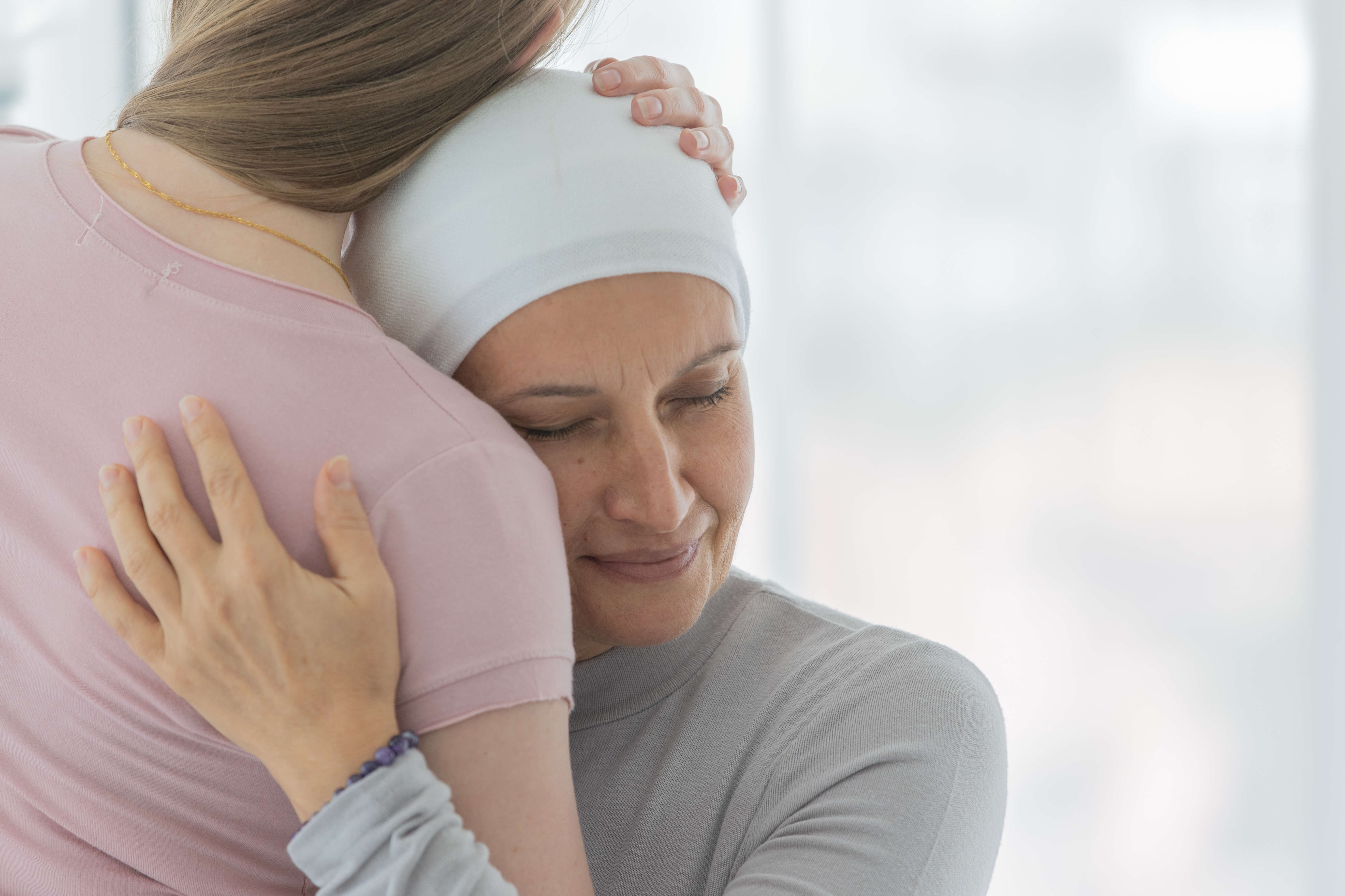 A cancer patient hugging a friend.