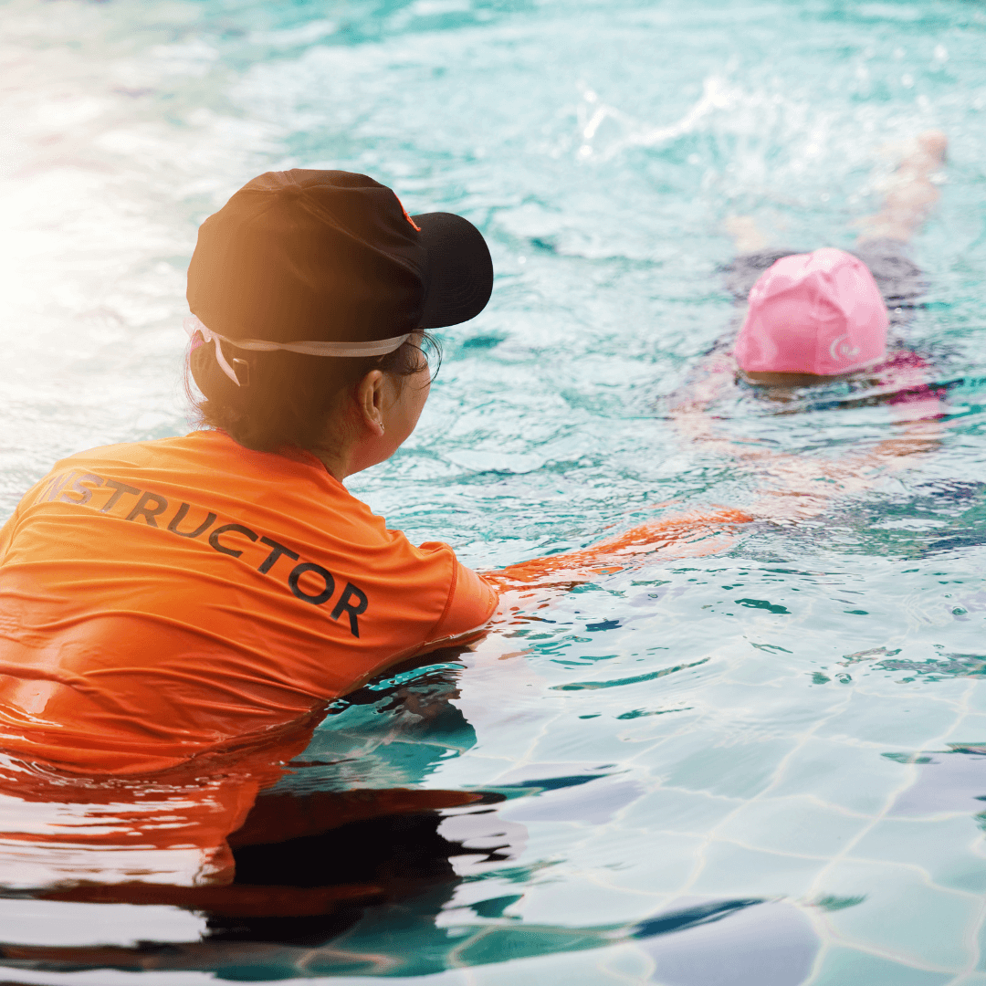 A swim instructor teaching lessons to a child in the water.