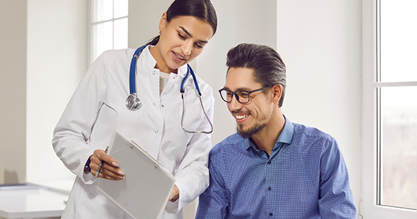 Provider showing clipboard to smiling patient.