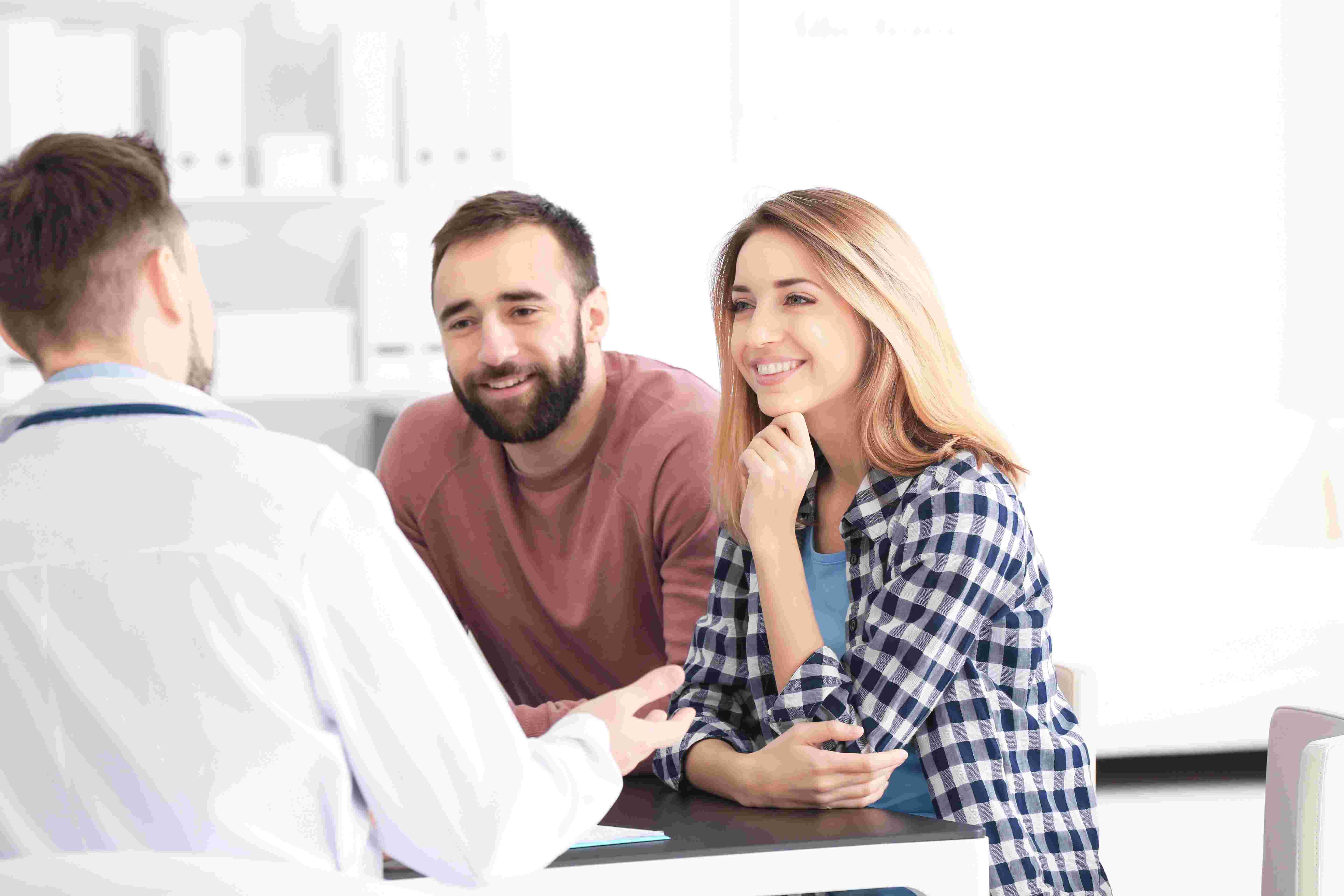 man and woman in pleasant conversation with physician at doctor's office